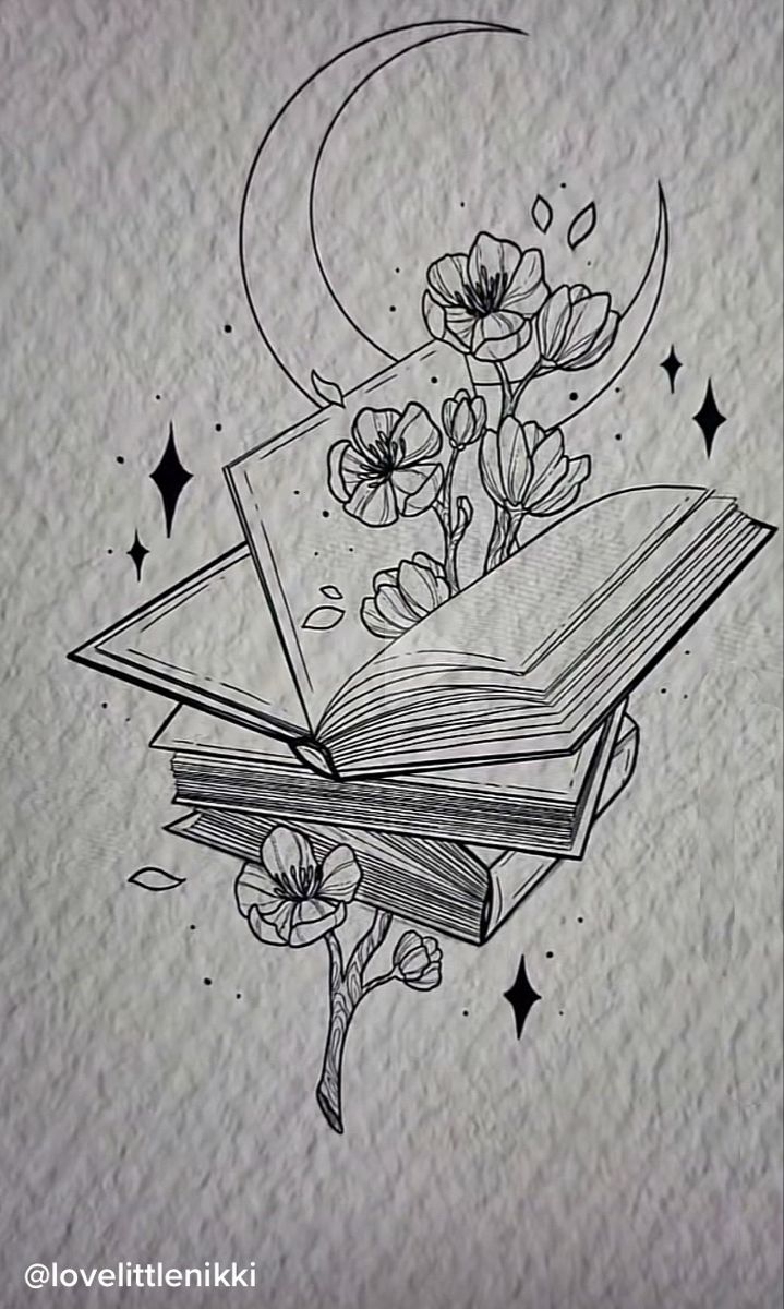 an open book sitting on top of a table next to a flower and moon tattoo