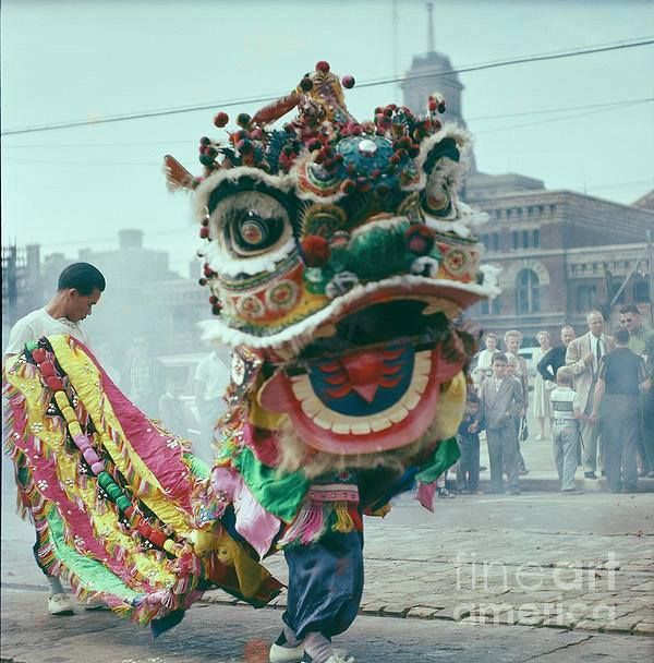 a man is walking down the street with a dragon costume