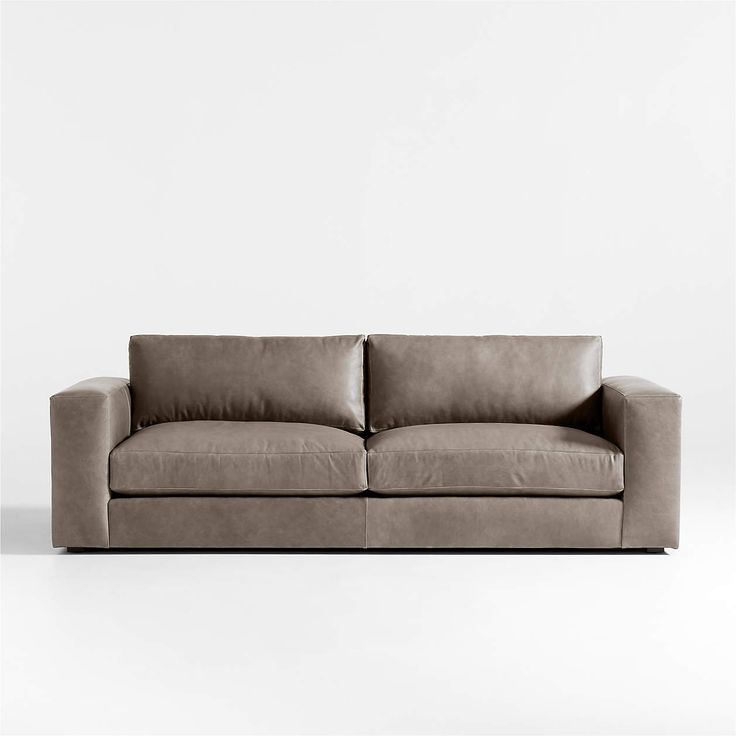 a gray couch sitting on top of a white floor