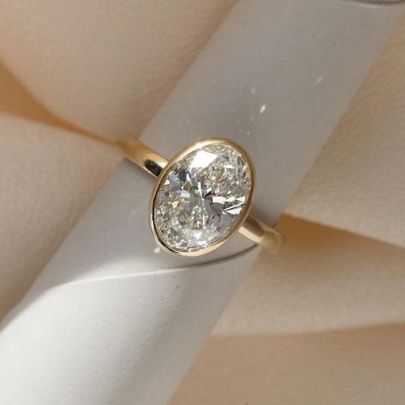 a diamond ring sitting on top of a white cloth