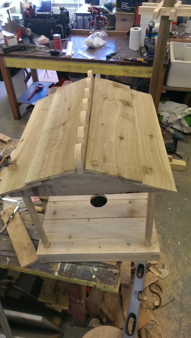 a bird house made out of wood in a workshop