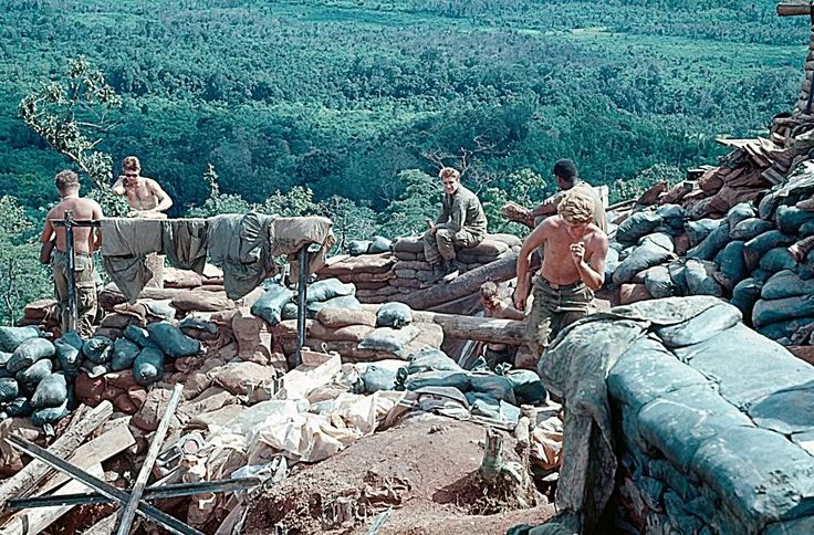 men are standing on top of a pile of rocks