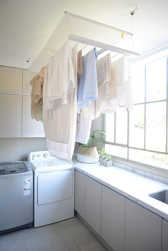 a laundry room with clothes hanging from the ceiling