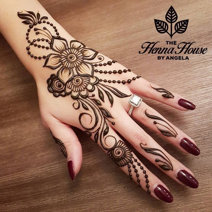 a woman's hand with henna tattoos on it