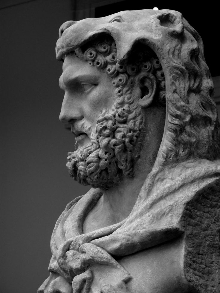 a black and white photo of a statue of a man with a beard wearing a scarf