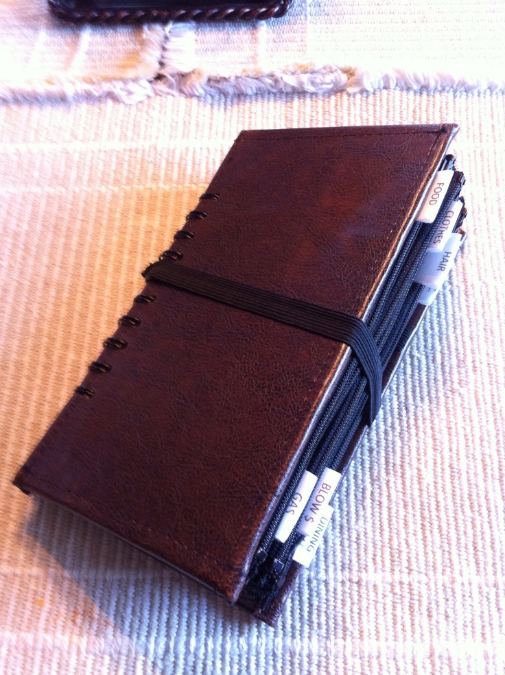 a brown leather notebook with three pens in it