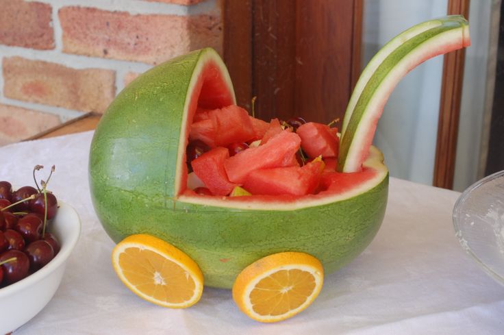 a watermelon shaped like a baby carriage with fruit in it