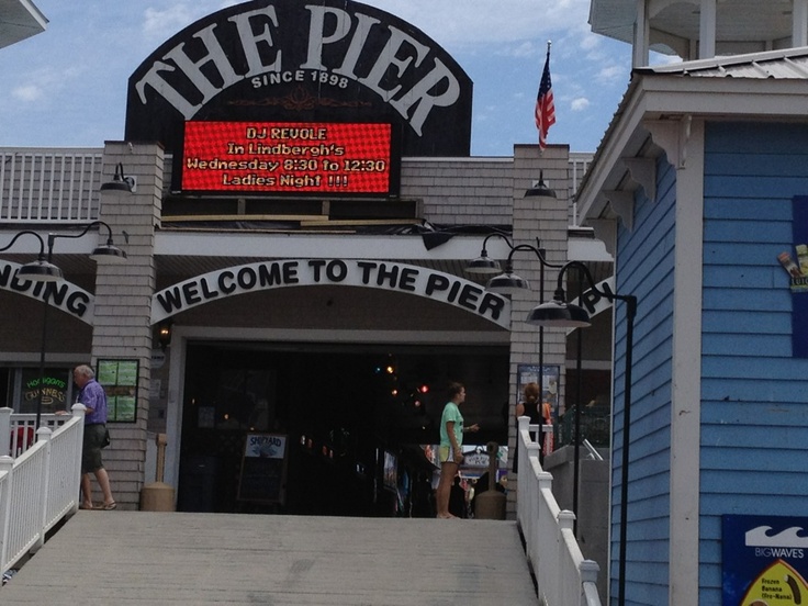 the pier is open for business and people are walking in to it on a sunny day