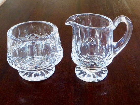 two clear glass pitchers sitting on top of a wooden table with the price tag $ 75 00