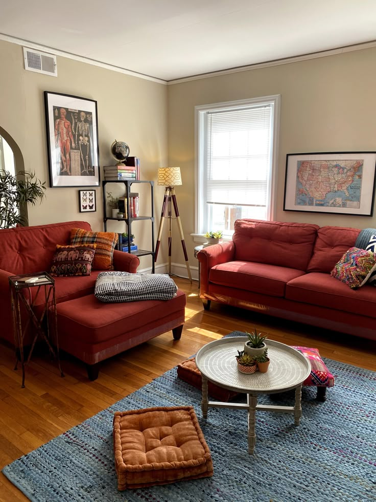 a living room filled with red couches and pillows