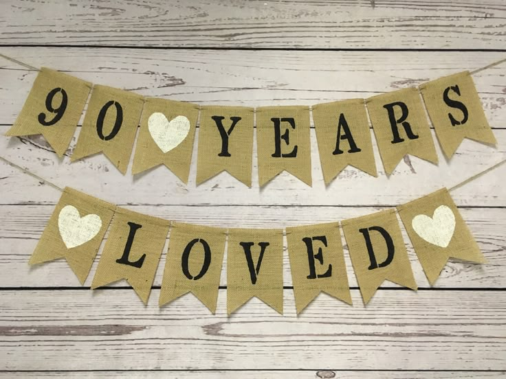 a banner that says 90 years loved with hearts and gold foil on the bottom,