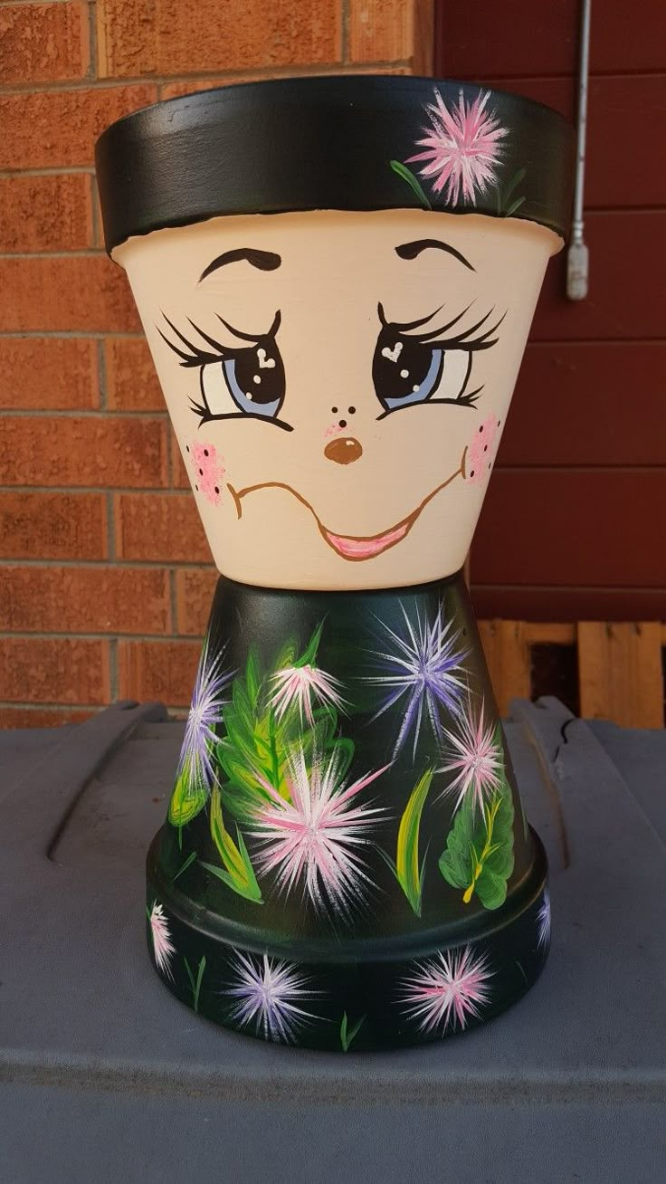 a flower pot with a face painted on it