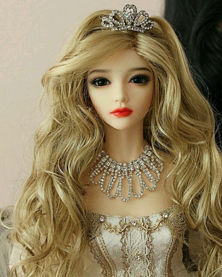 a doll with long blonde hair wearing a tiara and necklace on it's head