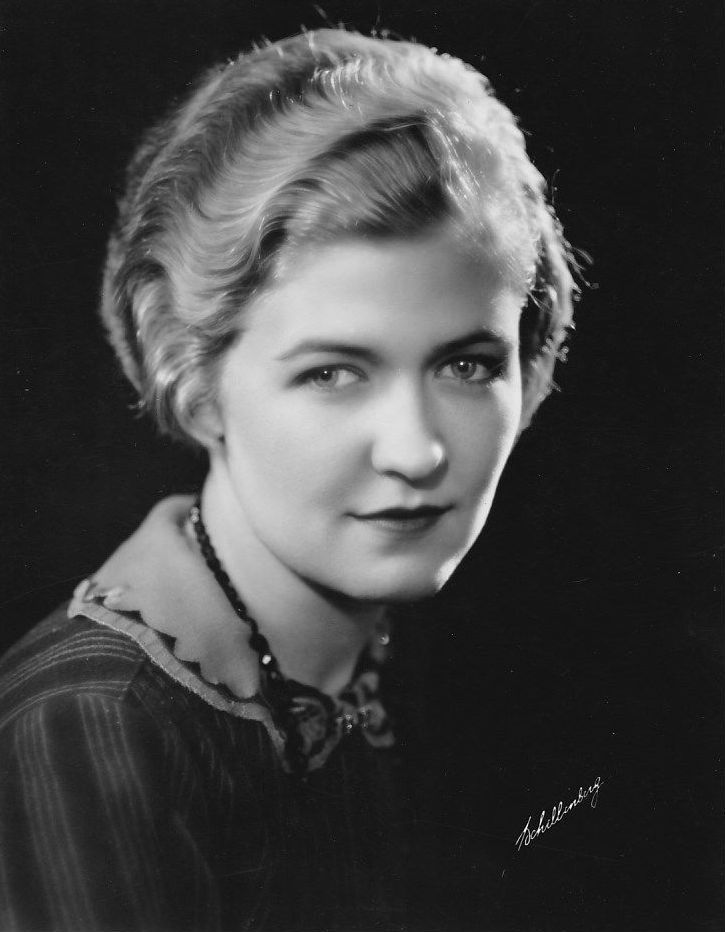 an old black and white photo of a woman with short blonde hair wearing a necklace