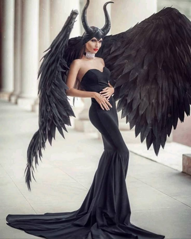 a woman dressed in black with large wings