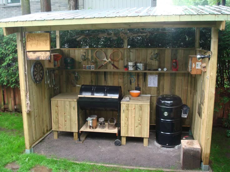 an outdoor kitchen made out of pallets and wood with a grill on the outside