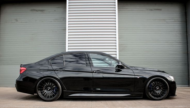 a black car parked in front of a garage door