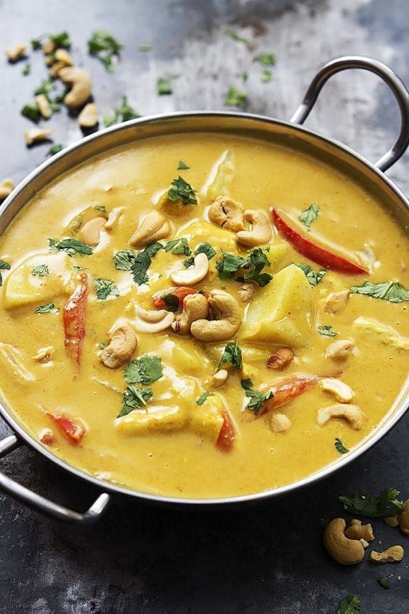 a pan filled with yellow curry and cashews