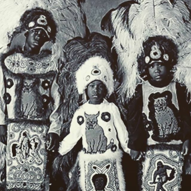 three children dressed in native american clothing and headdress, standing next to each other