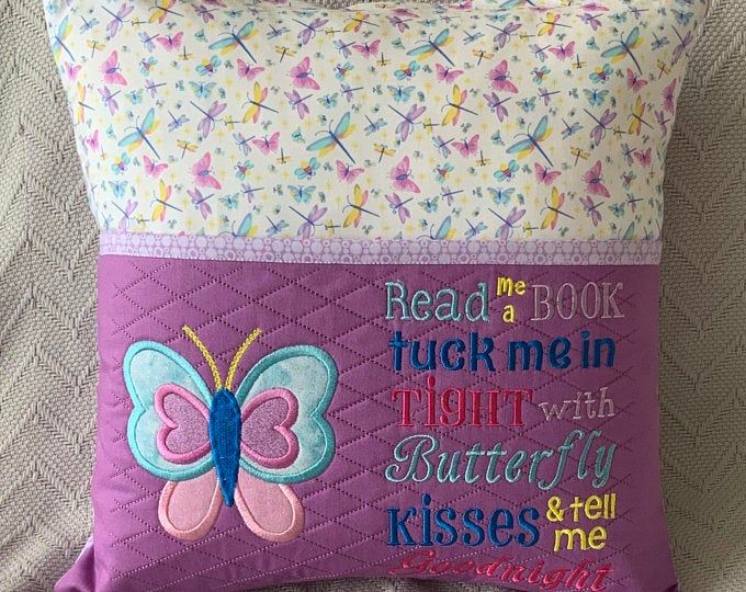 a purple pillow with a butterfly on it that says read me book and i'll tuck me in