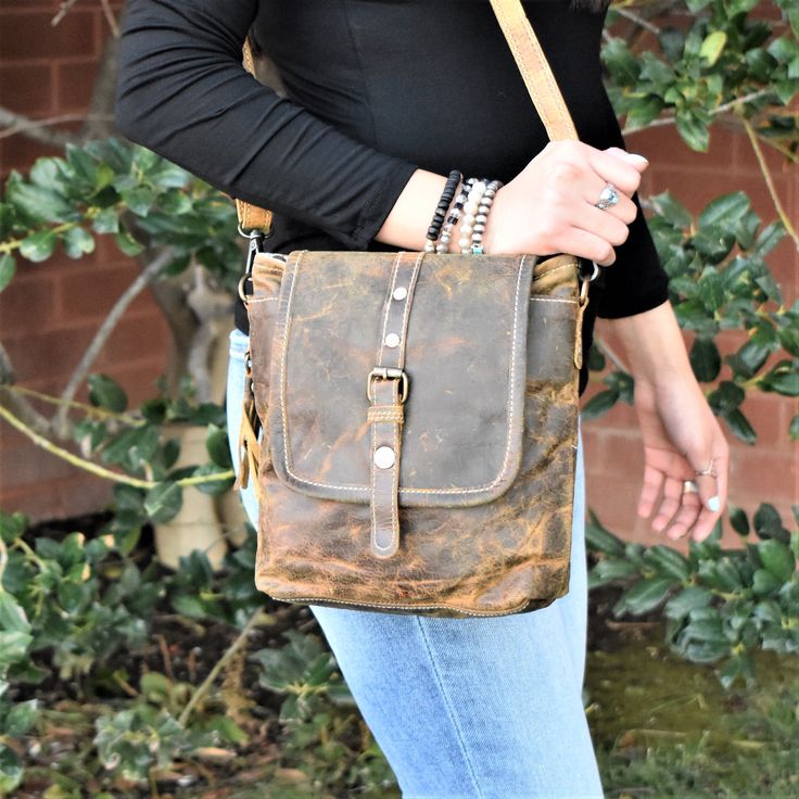 This genuine leather bag in rustic brown leather features a removable crossbody strap, and matches everything! Top zipper closure, with a button snap fold over flap. Back has a zipper pocket as well. 10"Wx10"Hx2.5"D strap: 112-24" Brown Satchel With Snap Closure For On-the-go, Fall Bags With Brass Hardware, Brown Leather Satchel With Snap Closure, Rugged Brown Bag With Adjustable Strap, Fall Brown Shoulder Bag With Snap Closure, Vintage Brown Shoulder Bag With Brass Hardware, Vintage Brown Shoulder Bag With Brass Hardware For Everyday, Distressed Brown Leather Shoulder Bag With Adjustable Strap, Distressed Brown Crossbody Shoulder Bag For Everyday Use