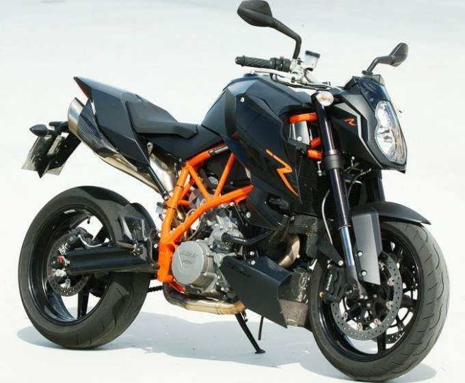 an orange and black motorcycle parked in the snow