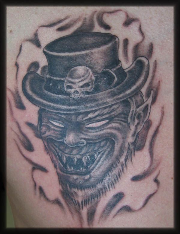 a man's back with a skull and top hat tattoo on it