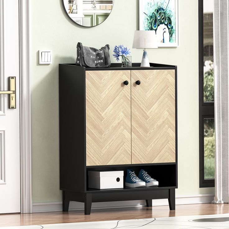 a black and wood cabinet with shoes on it in front of a wall mounted mirror