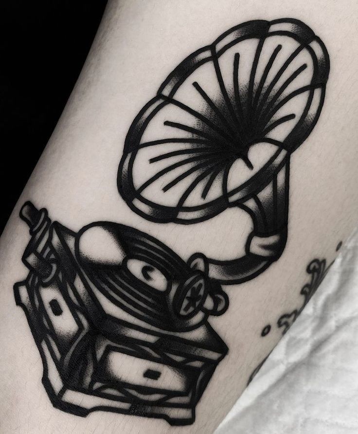 a black and white photo of a tattoo with an old fashioned record player on it