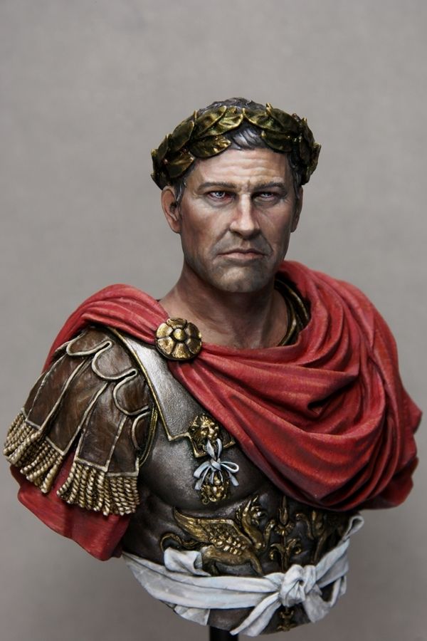 a busturine of a roman soldier wearing a red cape and gold headdress