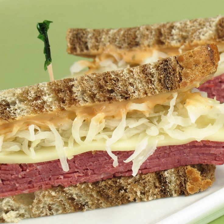 a close up of a sandwich on a plate with cheese and meat in the middle