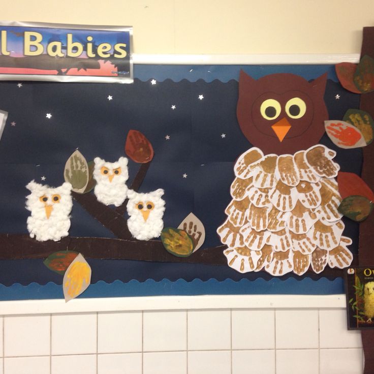 an owl and two owls on a tree branch in front of a sign for babies