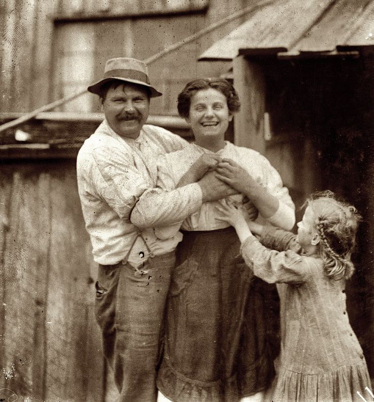 an old black and white photo of a man, woman and child posing for the camera