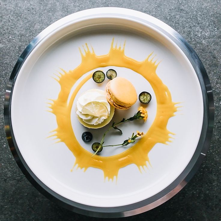 a white plate topped with an ice cream sandwich and cucumber slices covered in yellow sauce