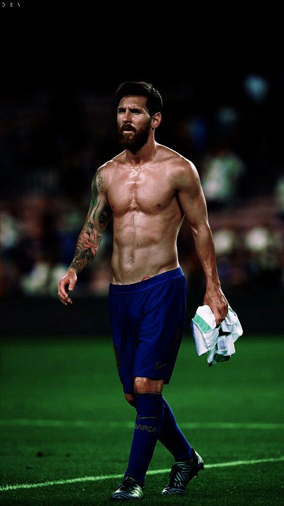 a shirtless man walking across a soccer field with the words dios on it