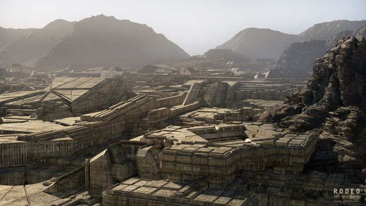 an aerial view of some ruins in the desert with mountains in the backgroud