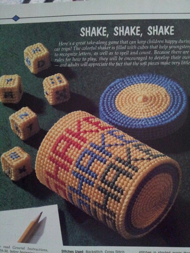 an advertisement for cross stitched toys with dices and pencils on the table