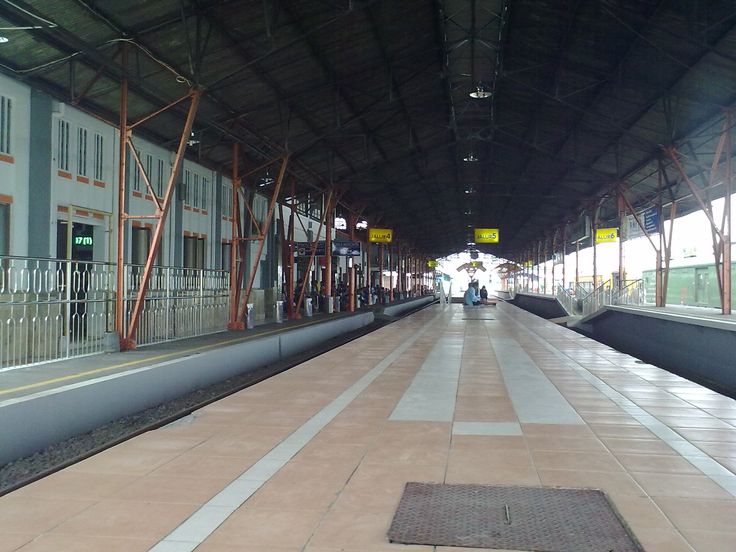 a train station with people waiting on the platform