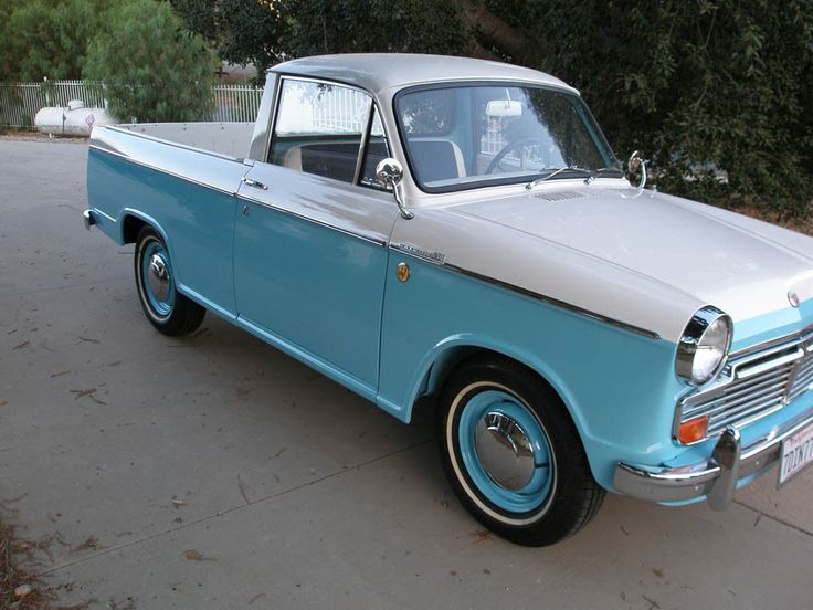 an old blue and white truck parked on the street