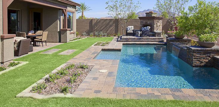 a backyard with a pool and patio furniture