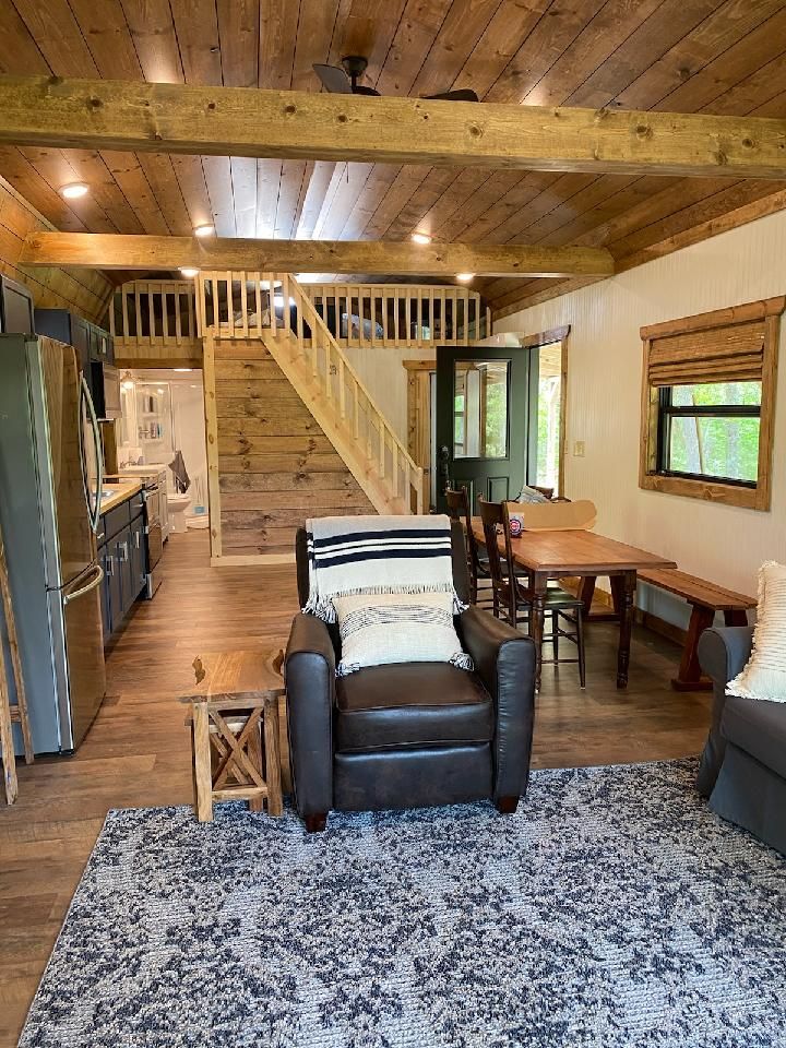 a living room filled with furniture and a wooden ceiling