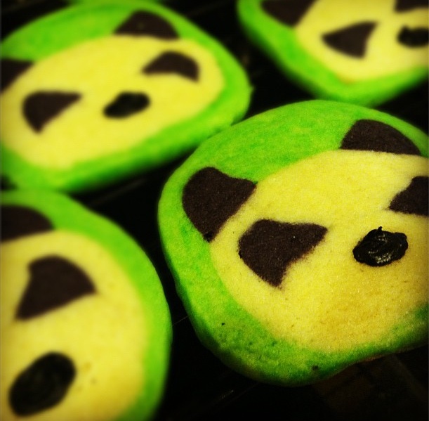 green and black decorated cookies with faces on them