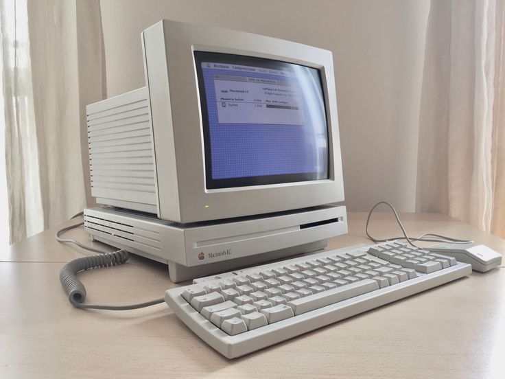 an old desktop computer sitting on top of a desk next to a keyboard and mouse