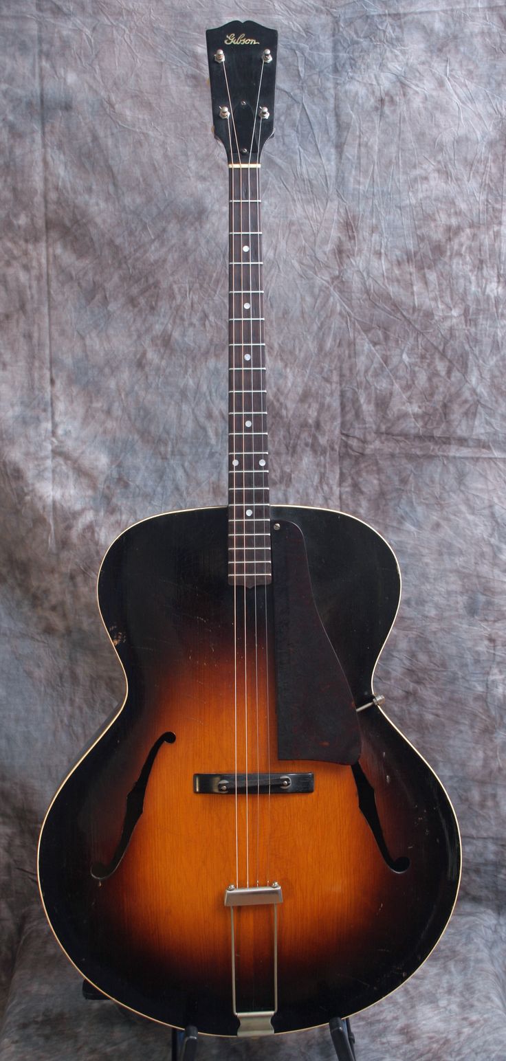 an acoustic guitar sitting on top of a stand