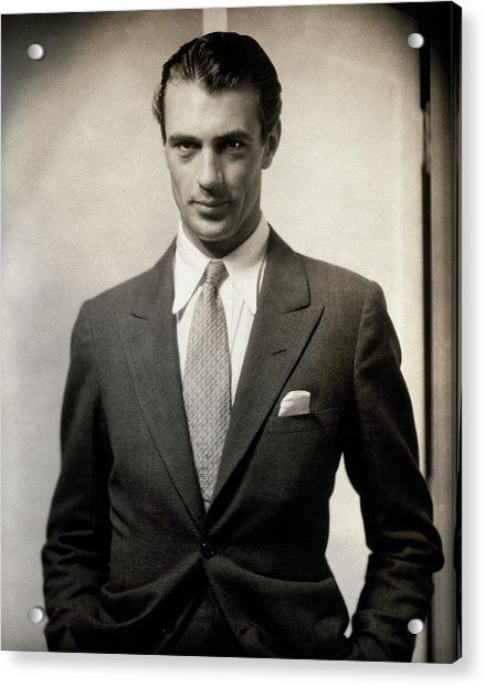 a black and white photo of a man in a suit with his hands in his pockets