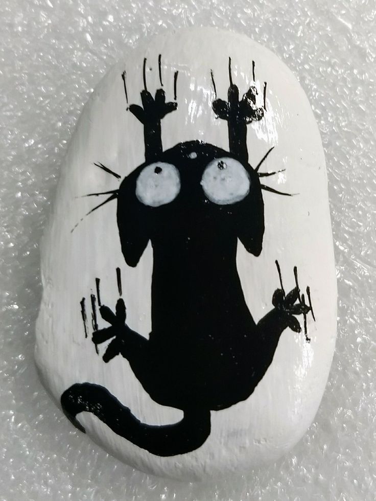 a painted rock with a black cat on it