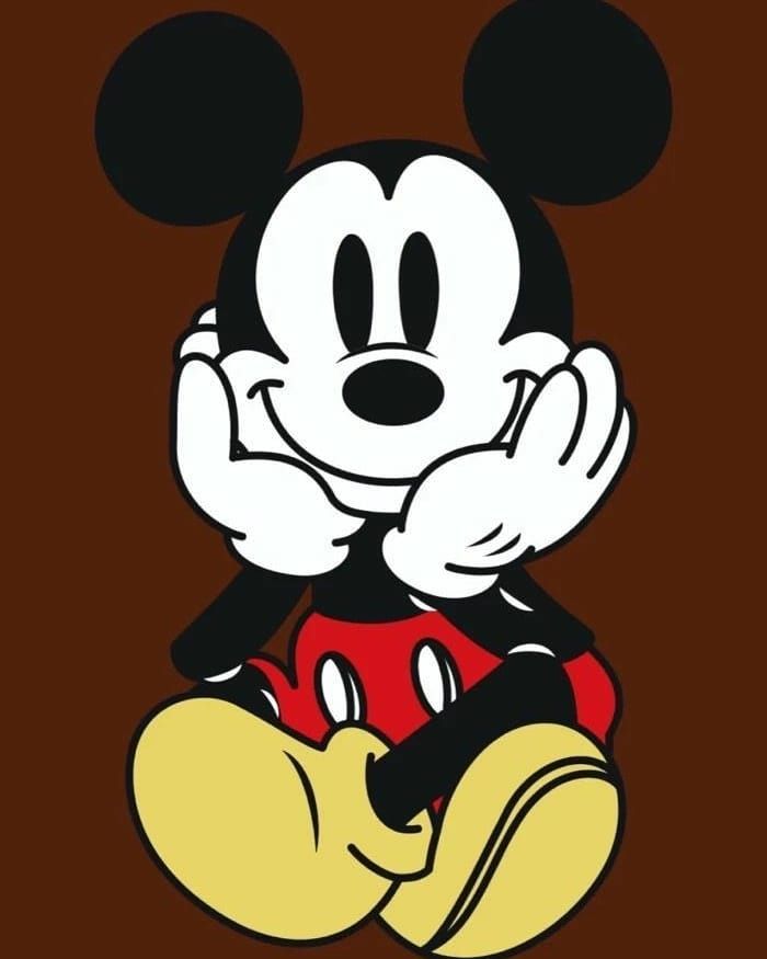 mickey mouse sitting on top of a brown background with the word disney written above it