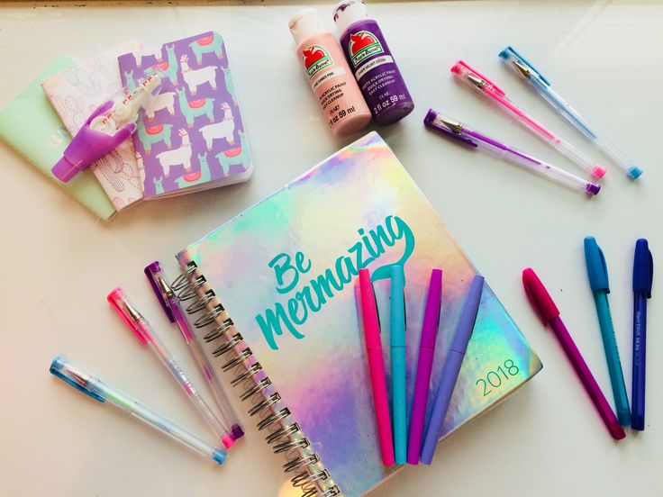 the contents of a personal planner laid out on a table next to pens and markers