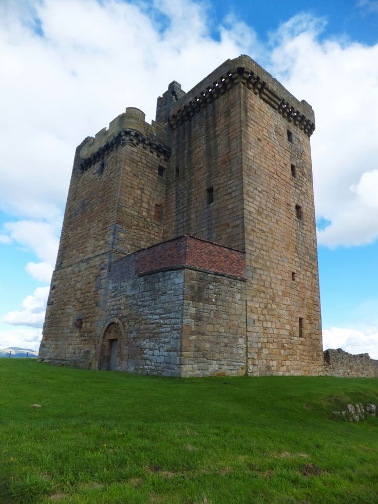 an old brick castle sitting on top of a lush green field