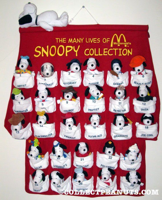 the many lives of snoopy collection is displayed on a bulletin board with stuffed animals